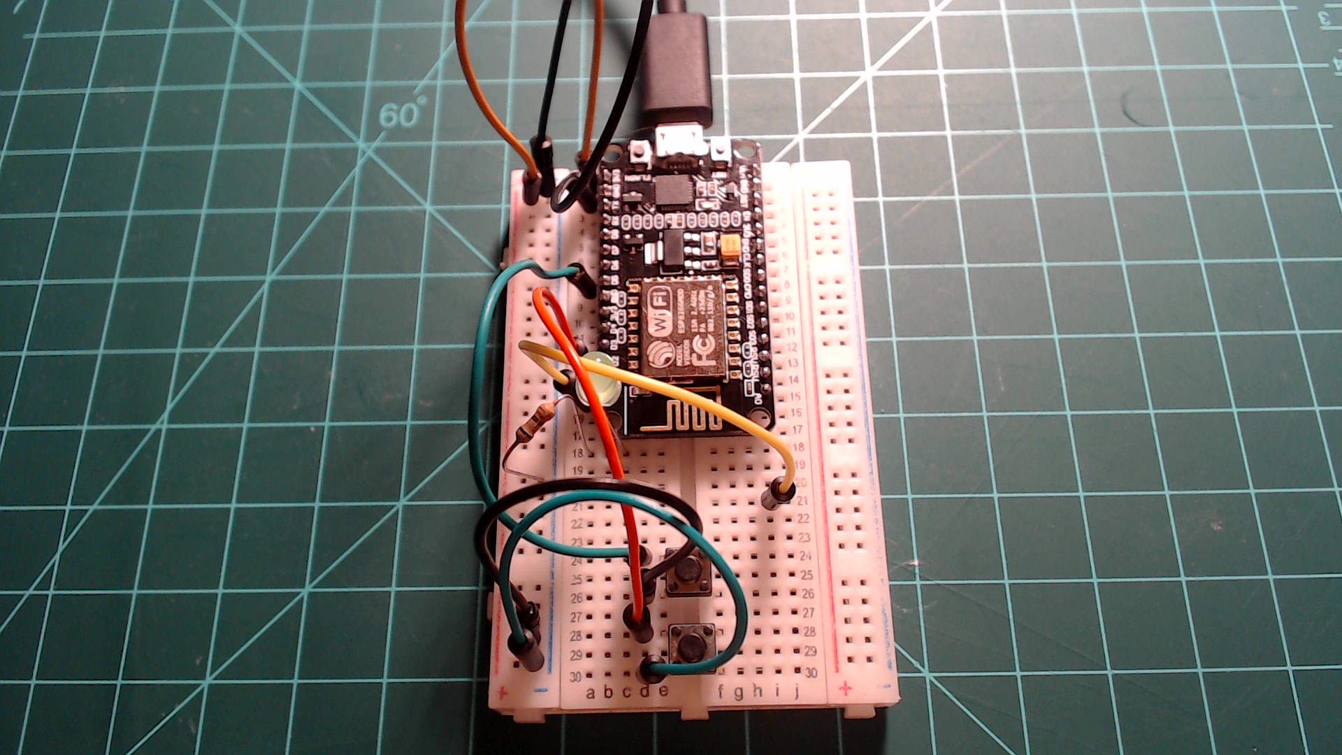 Two buttons, an LED, and a jumper wire connected to GPIO16 (D0).